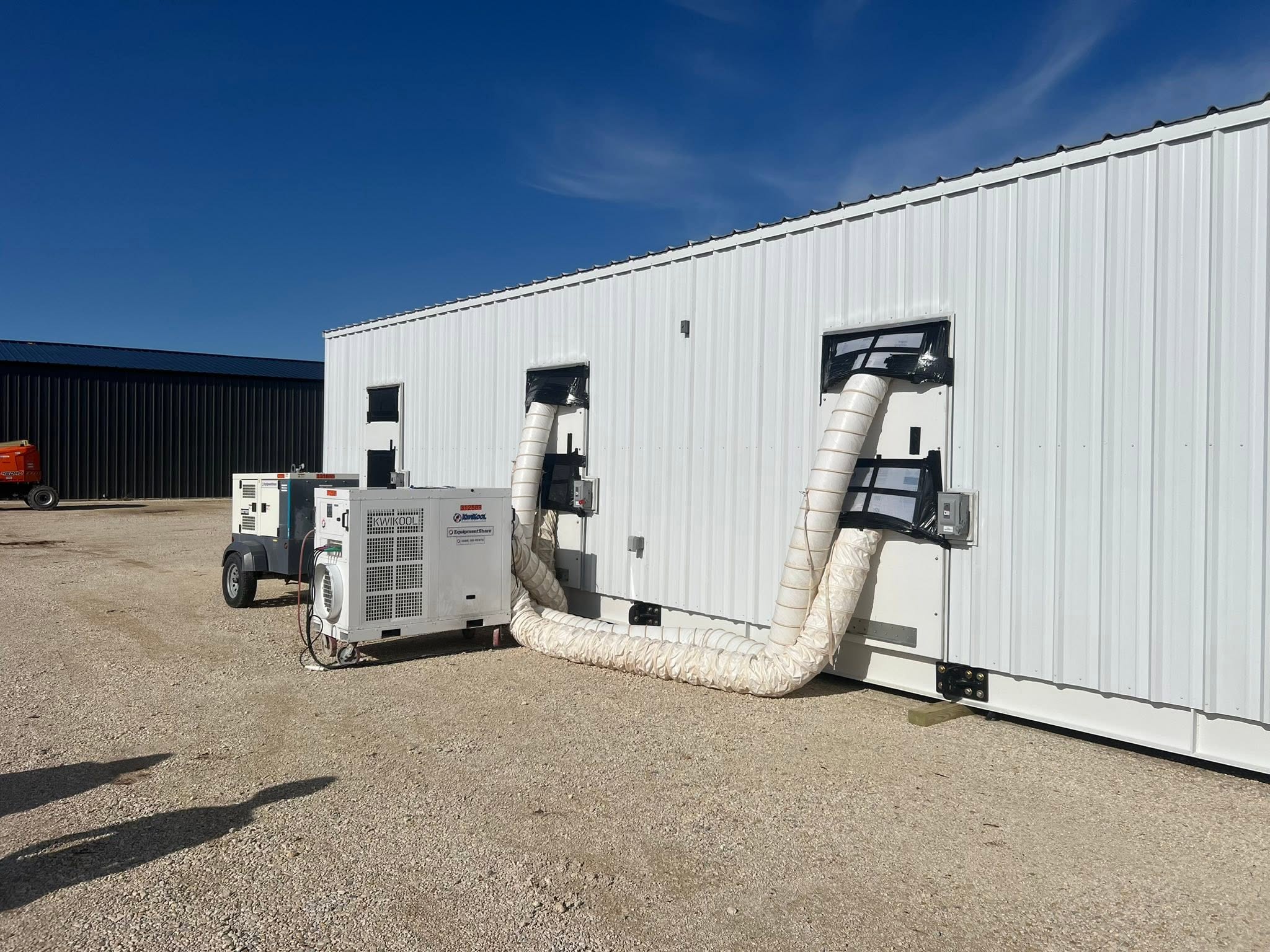 Generator and load-bank equipment installed beside a commercial building